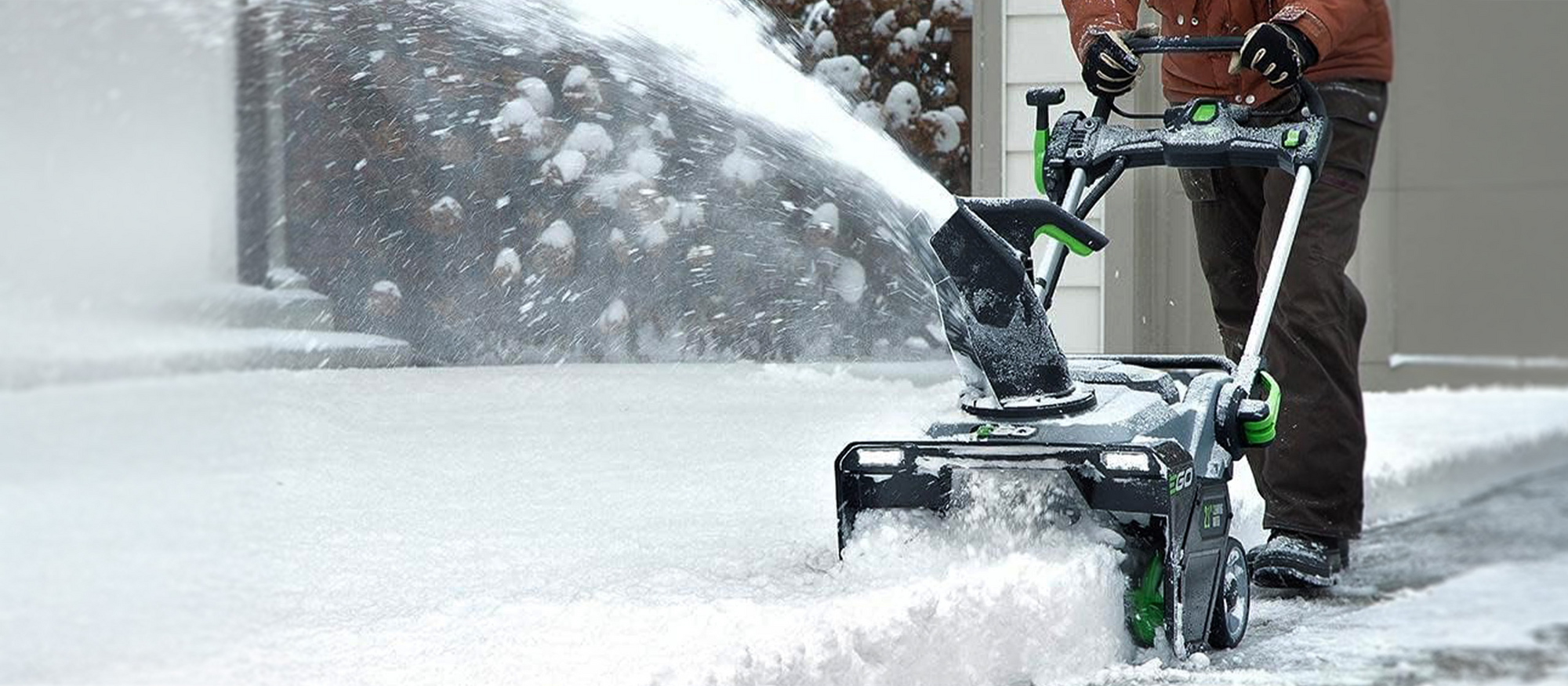 Effizientes Schneeräumen Mann befreit Einfahrt von Schnee mit Fräse von EGO Power+