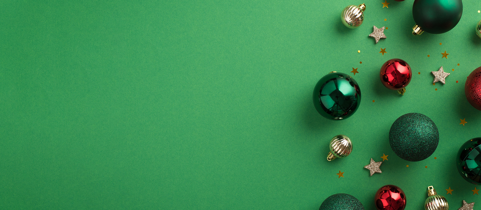 Wir sind für Sie da. Christbaumkugeln auf grünem Hintergrund